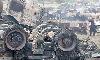 People look wreckages of burnt NATO trucks that  were destroyed in armed attack